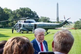President Trump speaks to reporters with Marine One and the Washington Monument visible in the background.