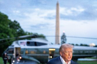 President Trump speaks to the press with Marine One and the Washington Monument in the background.