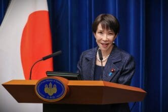 Prime Minister Sanae Takaichi speaking at a podium during a press conference.