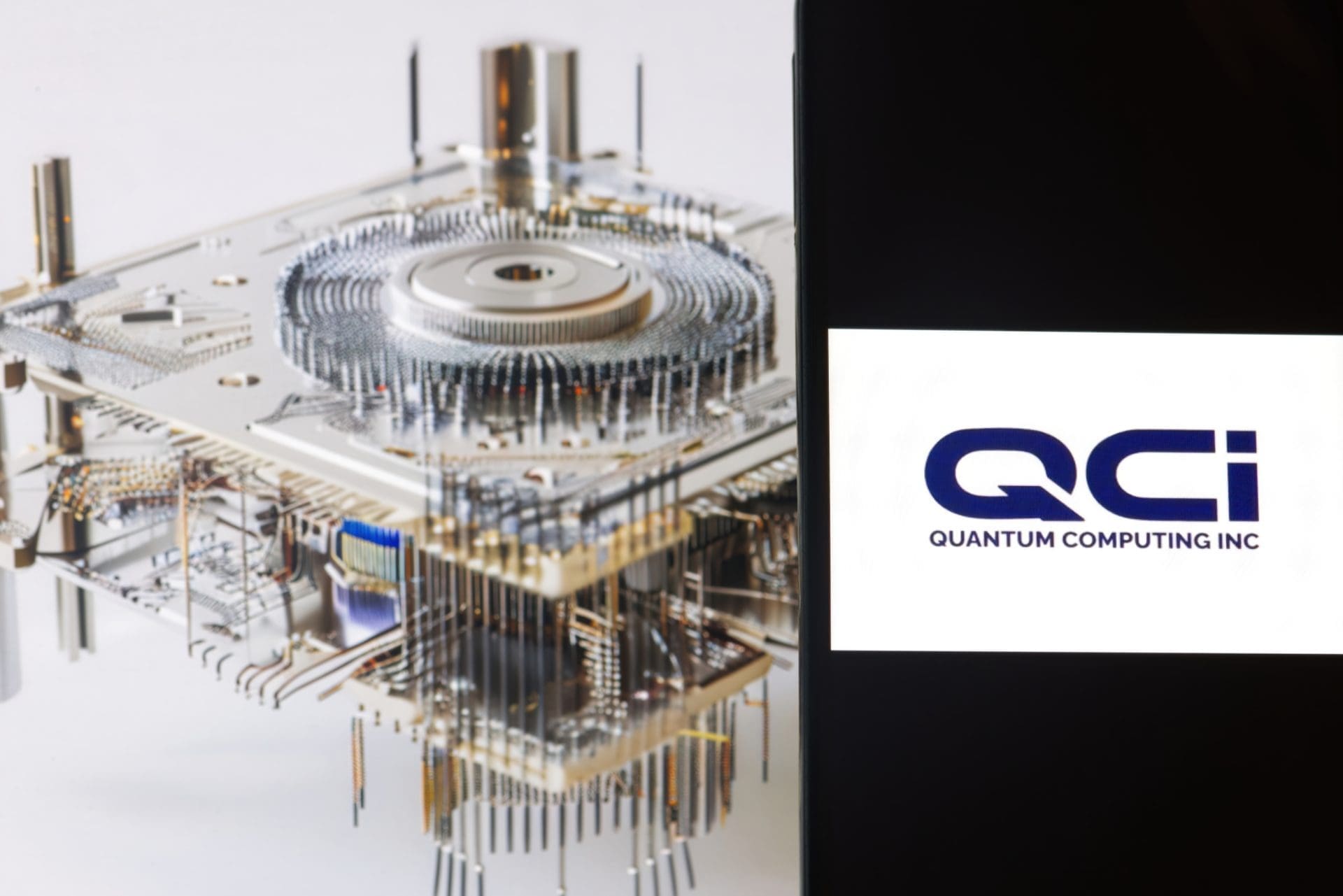 The Quantum Computing Inc. (QCi) logo displayed next to a complex quantum computer.