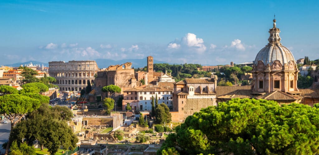 A sunny aerial view of Rome, Italy, showing the Colosseum and the Roman Forum.