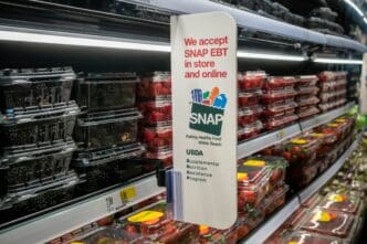 A sign in a supermarket aisle indicating acceptance of SNAP EBT payments.