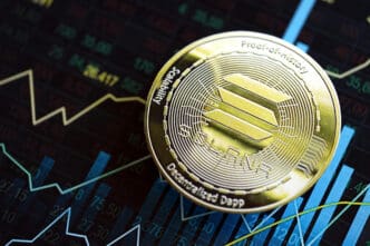A physical gold Solana coin lies on a screen showing a digital cryptocurrency market chart with fluctuating data and trend lines.