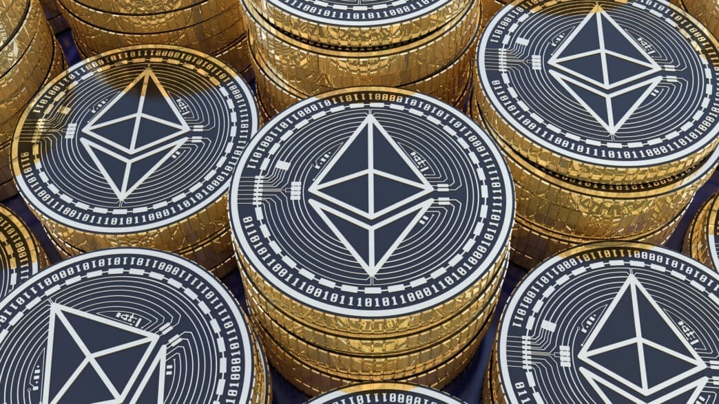 Close-up, high-angle view of many stacks of gold and black Ethereum cryptocurrency coins.