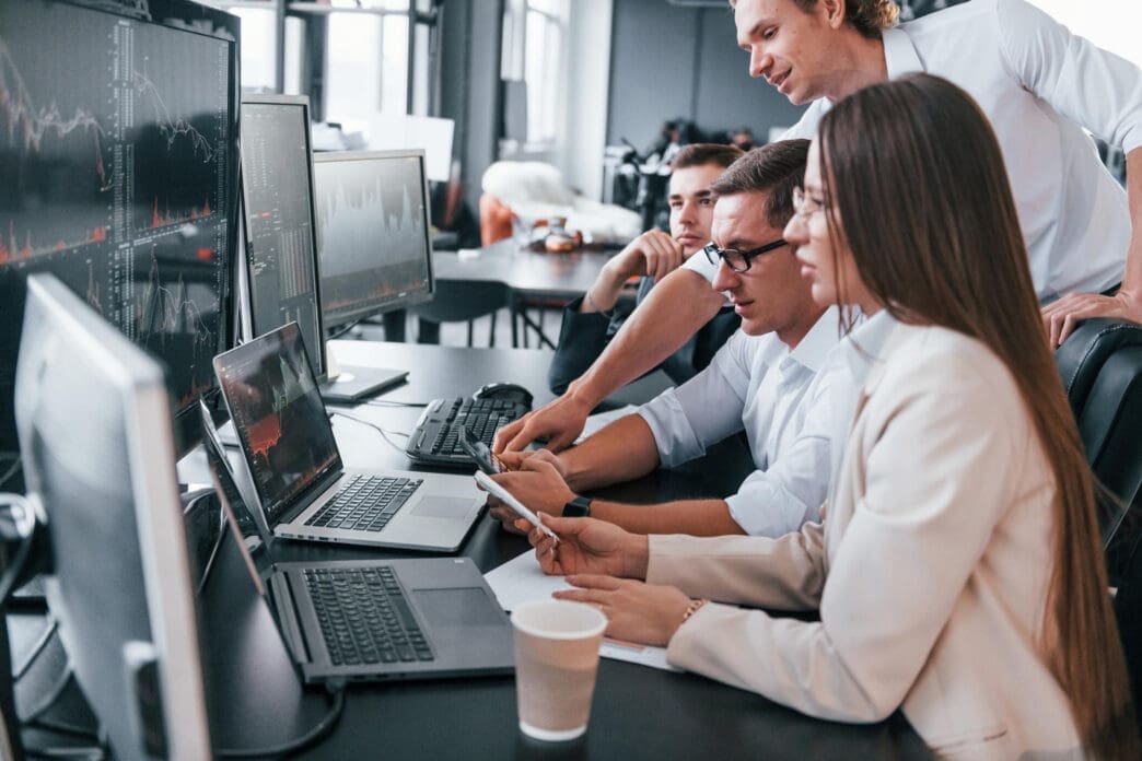 Team looking at financial data on computers in an office