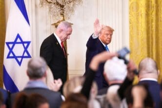 President Donald Trump waves to the press while Israeli Prime Minister Benjamin Netanyahu stands nearby during a joint White House news conference.
