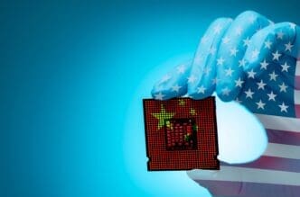 A hand in a US flag glove holds a computer chip with a Chinese flag on it.