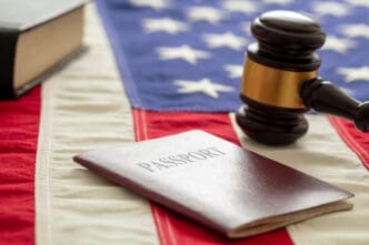 A passport and a judge's gavel rest on an American flag, symbolizing legal matters of immigration and citizenship.