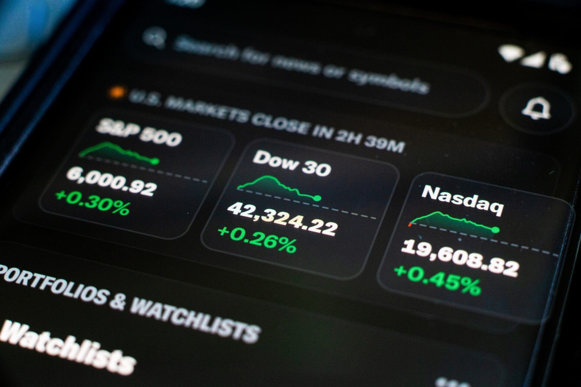A smartphone screen shows a stock app with S&P 500, Dow 30, and Nasdaq indices all showing gains.
