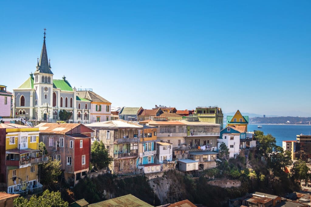 The colorful, dense hillside houses and prominent Lutheran Church spire of Valparaiso, Chile, overlooking the Pacific Ocean