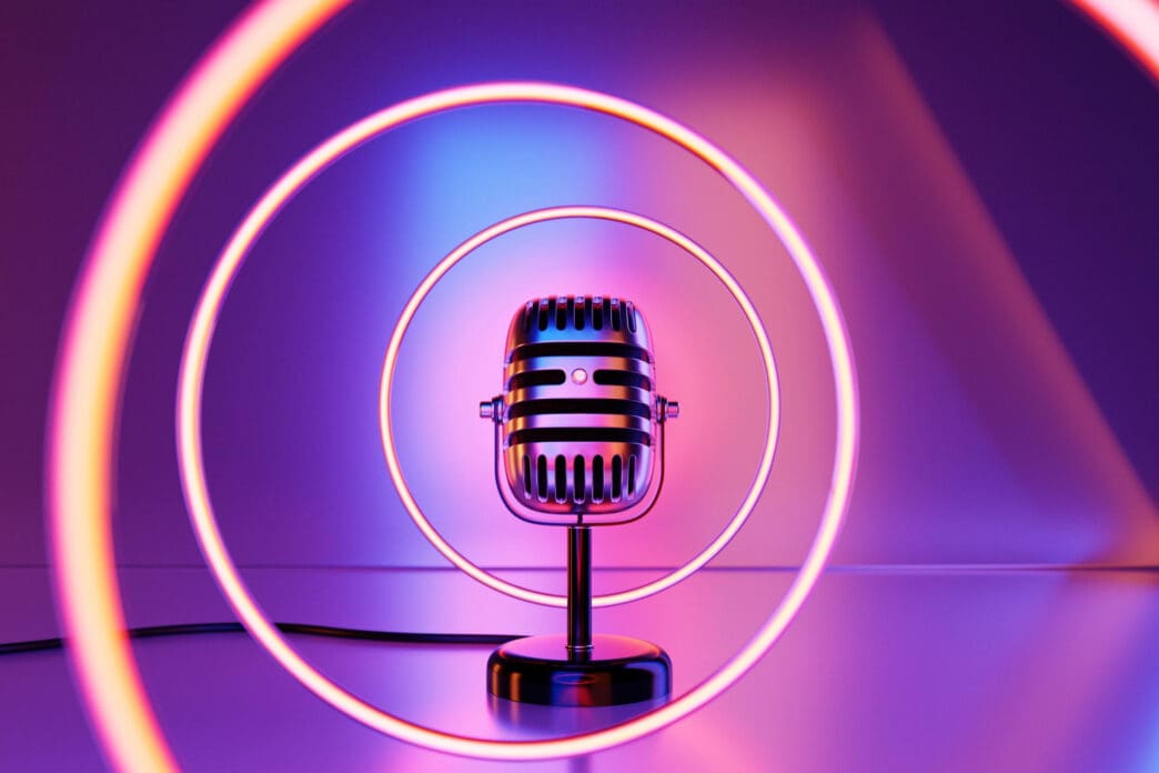 A vintage microphone sits in front of glowing neon rings in a purple room.