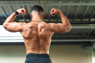 Back view of a muscular, shirtless man flexing his back muscles.