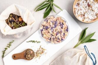 Close-up of cotton bags filled with various herbs, salt, and essential oils arranged for a natural health display.
