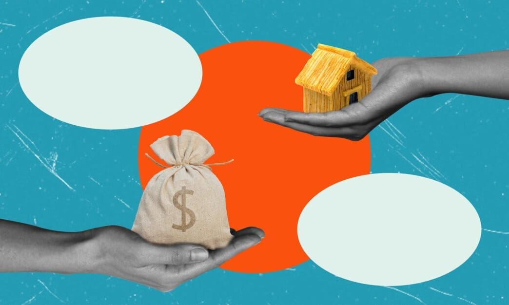 Two men in suits shake hands in front of a house, symbolizing a real estate transaction.