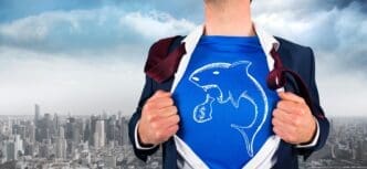 A businessman dramatically opens his dress shirt, revealing a superhero emblem, as he stands on a balcony overlooking a cityscape.