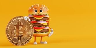 A cartoon burger mascot holds a golden Bitcoin coin.