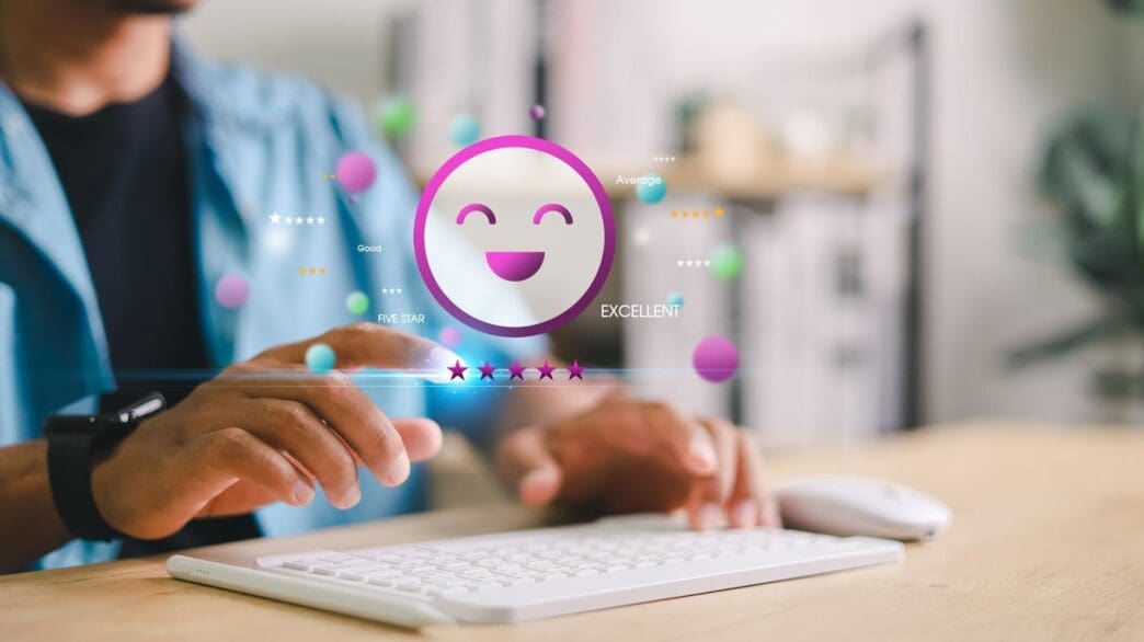 Close-up of a hand holding a smartphone displaying a glowing happy face and a five-star rating.