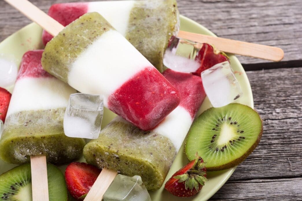 A refreshing popsicle featuring layers of strawberry yogurt and kiwi.