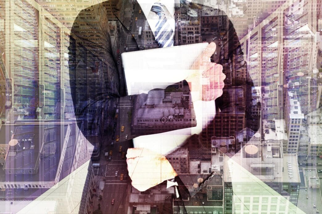 Businessman gripping a laptop with both hands, suggesting stress or protectiveness.