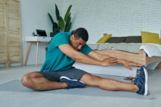 A young multiracial man in athletic wear exercises confidently in a home setting.