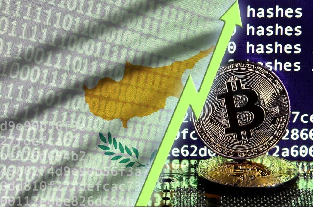 The Cyprus flag and a rising green arrow are displayed on a bitcoin mining screen, with two physical golden bitcoins in the foreground.