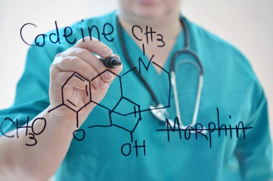 A doctor writes on a glass board displaying the word "Medford."