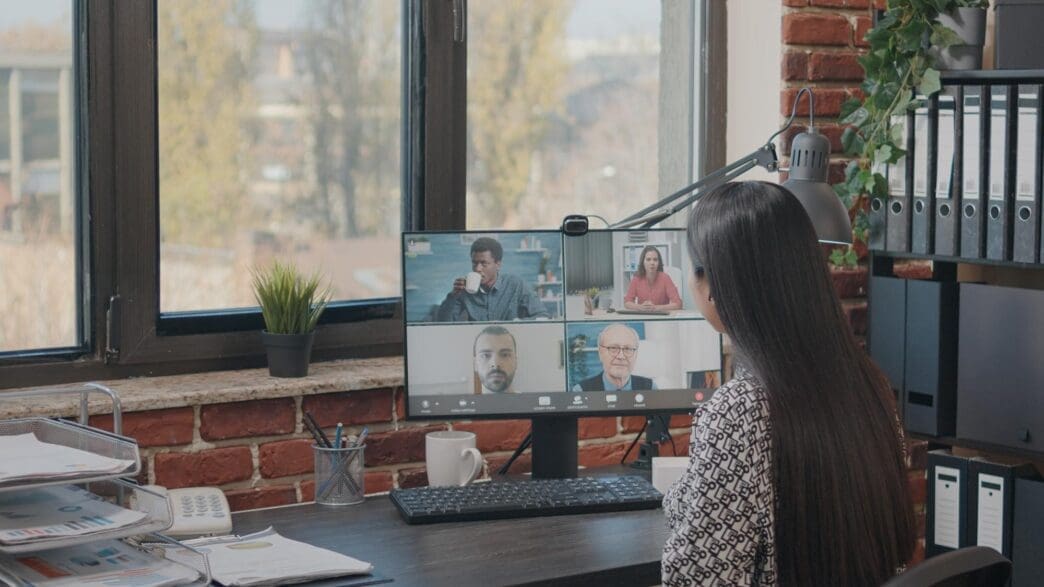 Woman in a video call with colleagues, likely for a business meeting or remote work.