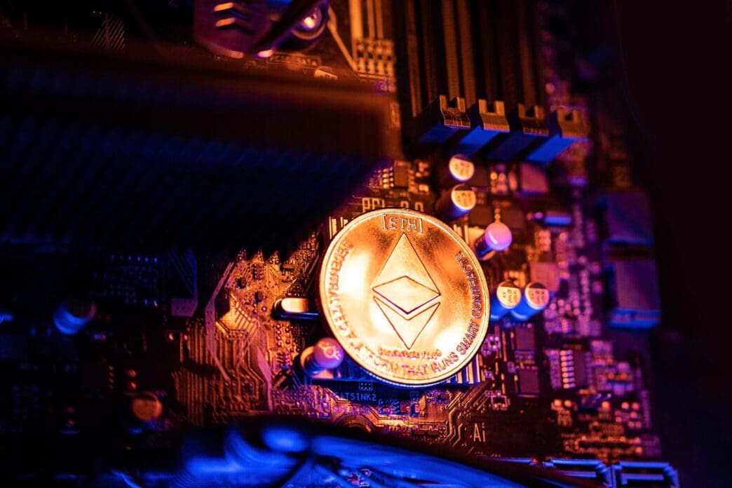 An Ethereum cryptocurrency coin rests on a computer motherboard, illustrating the concept of cryptocurrency mining.