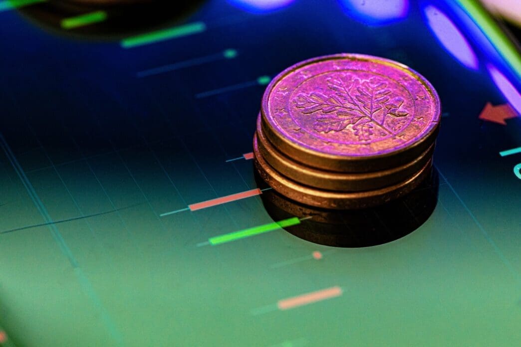 Close-up of a Euro coin resting on a stock chart, representing a financial investment concept.
