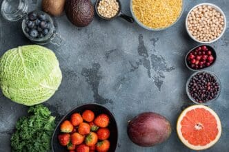 Flat lay of healthy products arranged in a frame or border on a gray table.