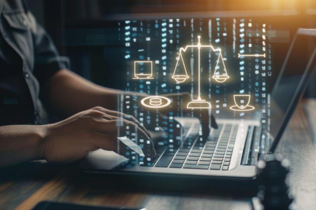 A gavel rests on a table next to a laptop and smartphone, symbolizing the intersection of law and technology.