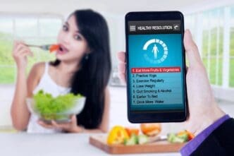 Woman eats a salad while looking at a list of healthy resolutions.