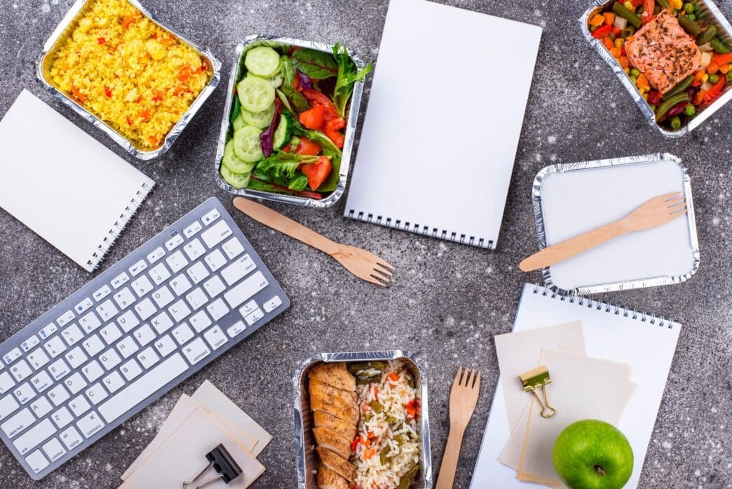 A person receives a food delivery at their office desk.