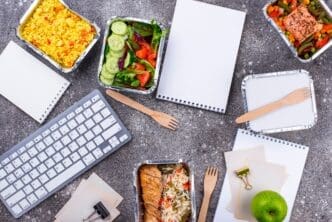 A person receives a food delivery at their office desk.