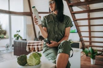 Woman's midsection holding a smartphone indoors.