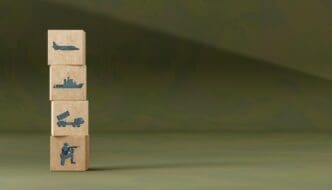 Wooden block icons depicting various military equipment, such as tanks, aircraft, and artillery, are arranged on a camouflage background.