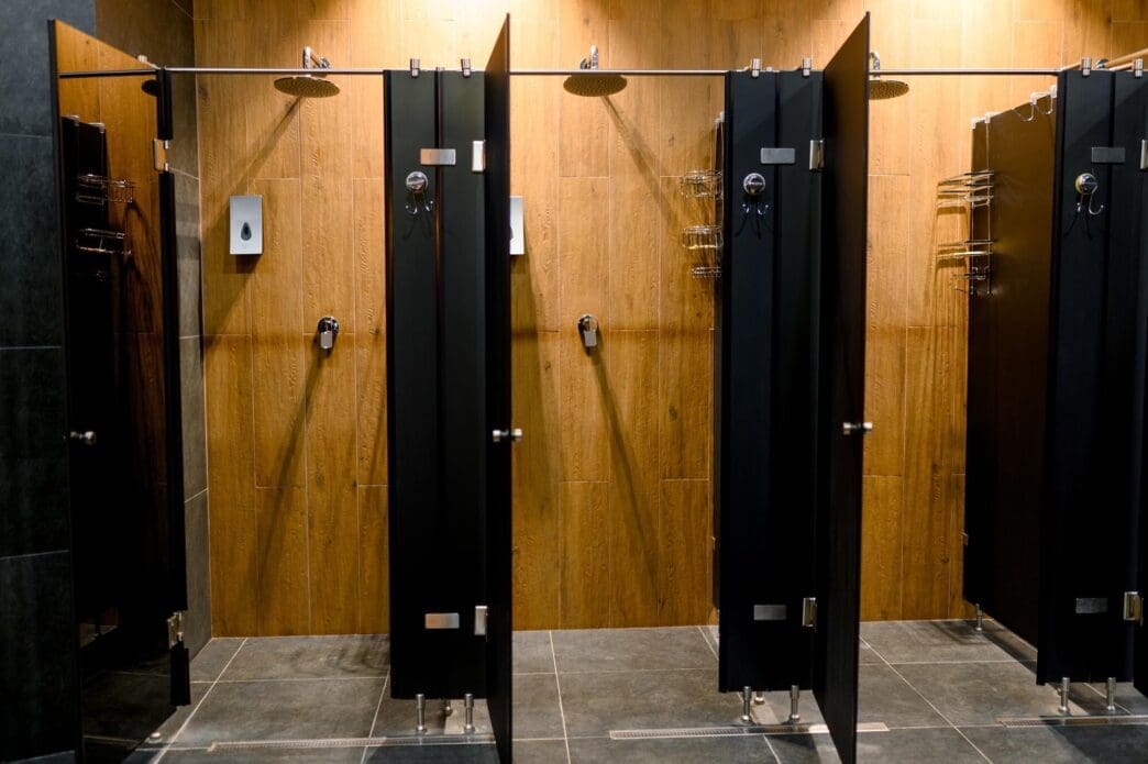 Modern shower cabin with wooden paneling, showcasing chrome fixtures.