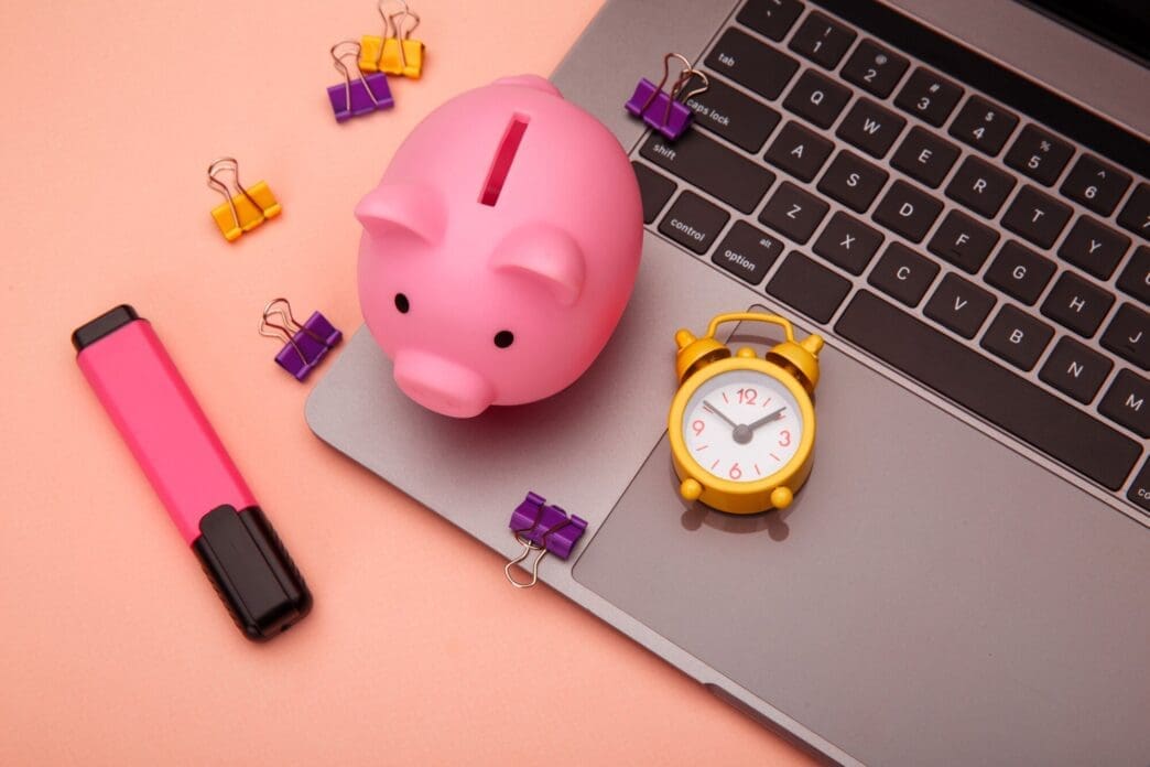 A modern desk workspace features a touchscreen laptop and other business and finance-related items.