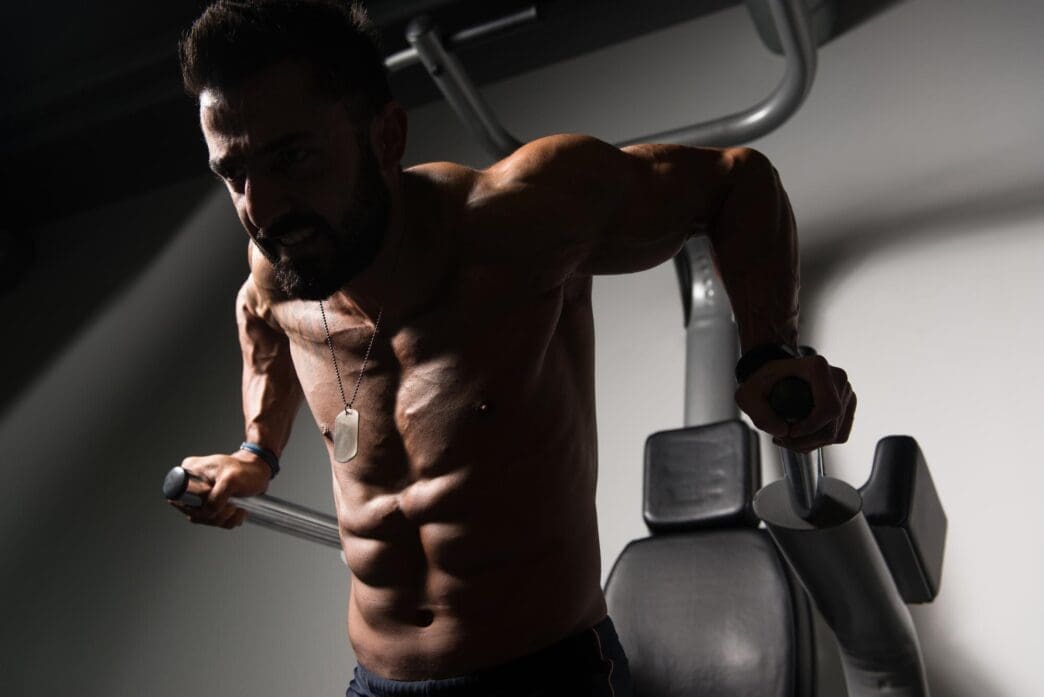 A person performs a tricep and chest exercise on parallel bars.