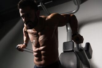 A person performs a tricep and chest exercise on parallel bars.