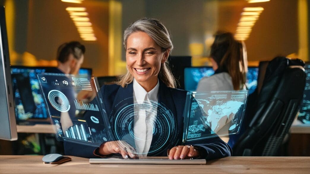 A person works on a computer with holographic projections of artificial intelligence elements floating nearby.