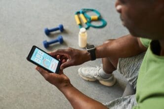 Senior Black man smiles while looking at his smartphone, tracking his fitness progress.