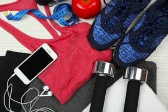 A collection of sports equipment, including a ball, shoes, and a water bottle, is arranged on a light-colored surface.