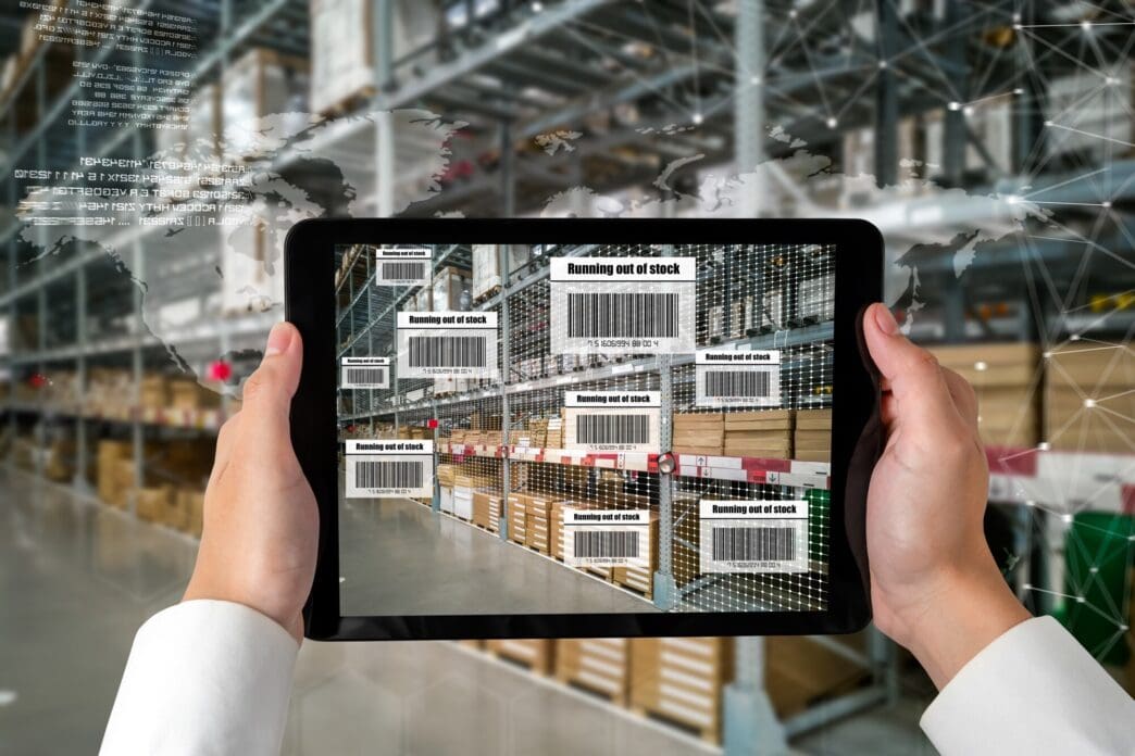 A person wearing augmented reality glasses interacts with a virtual interface displaying data about items in a warehouse.
