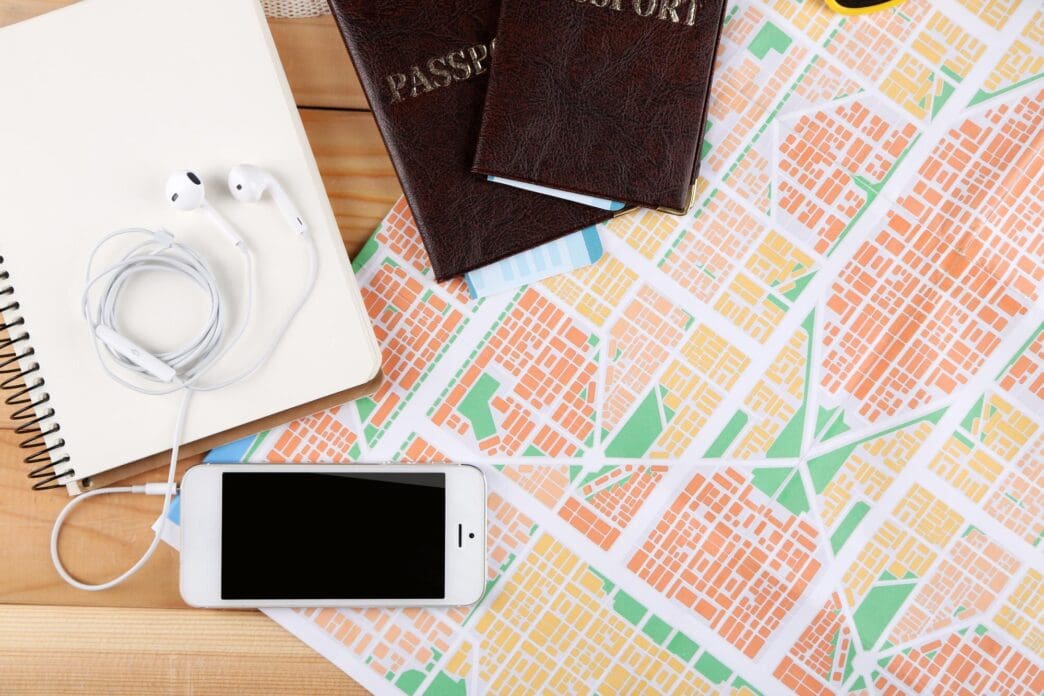 Close-up of sunglasses, a passport, and a map, representing travel preparation.