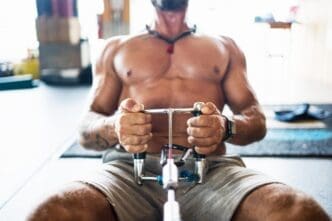 An unrecognizable person performs traction exercises on a specialized gym machine.