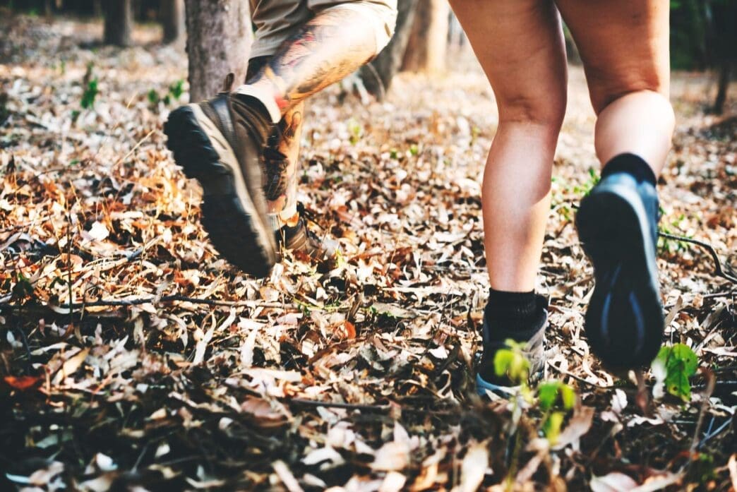 A person with a backpack hikes along a scenic trail, exploring nature.