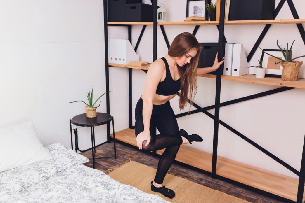 A woman stretches at home, demonstrating a healthy lifestyle.