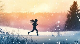 Woman running through a snowy landscape with snowflakes falling.