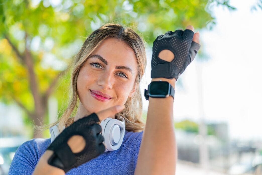 A young woman with a sporty watch smiles.